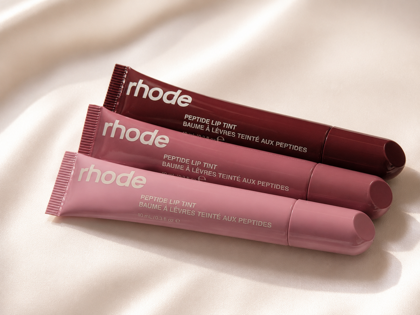 Three Rhode Peptide Lip Tints in pink, mauve and berry